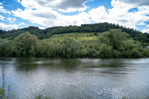 Das Licht tanzte über den Hang, während die Wolken ihre Schatten langsam über die Reben schoben. Die Mosel wirkte wie ein Spiegel, der Himmel und Landschaft zu einem einzigen Gemälde verschmelzen ließ