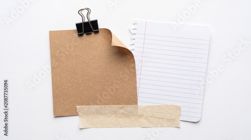 Brown kraft paper and lined note paper with black clip