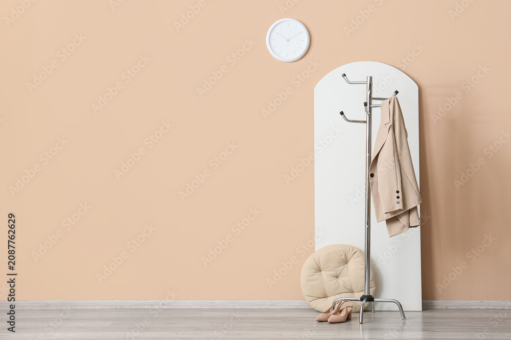 Naklejka premium Minimalist interior with coat rack, beige jacket, and shoes