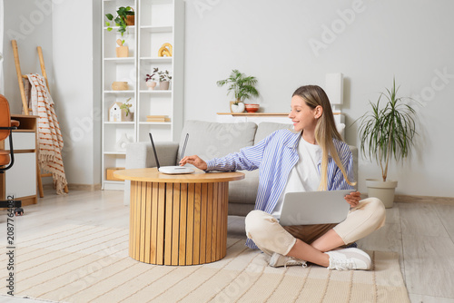 Young woman using laptop an...