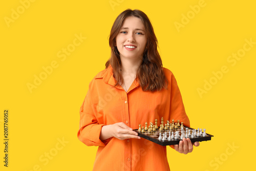 Young woman holding chessbo...