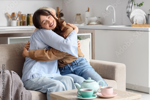 Young woman hugging elderly...