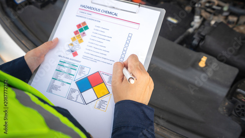 Foto A safety engineer is using pen to rating the health risk assessment level of chemical hazardous material in the paperwork form