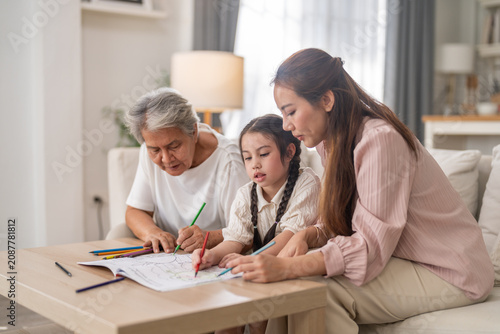 Asian multi generational family of grandmother mother and little girl drawing together at home, Child creativity, family bonding, happy quality time, educational development and lifestyle activity