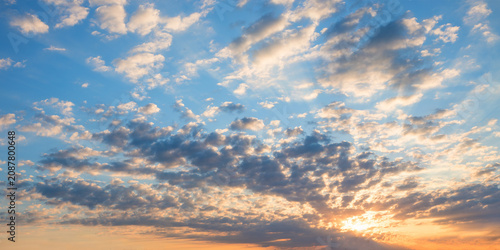 Foto Evening sky scene with an orange glow beneath gray fleecy clouds.