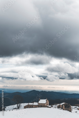 Obraz na płótnie dramatic landscape in lessinia with dark clouds and lonely stone house