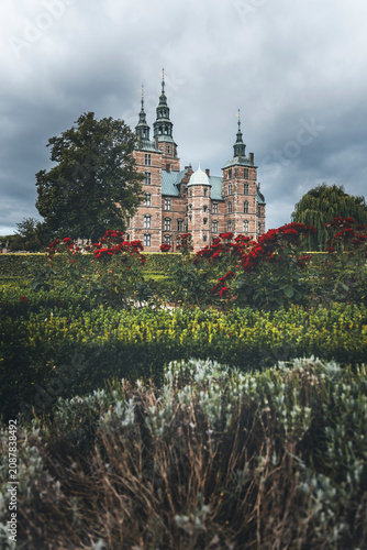 Photography rosenborg slot in copenhagen on a cloudy day and plants of the park in the foreg
