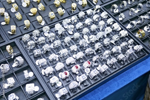 Assorted sparkling silver rings displayed on velvet trays at a local fair in Vinh Long Vietnam