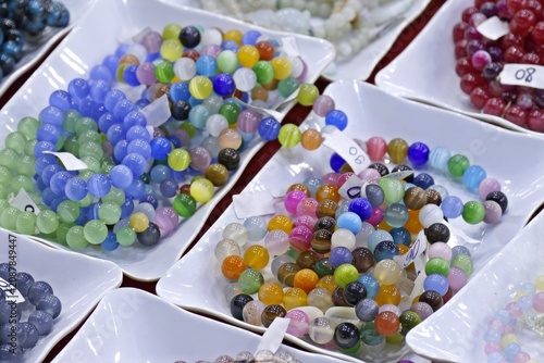 Photos Vibrant Multi-Colored Beaded Jewelry Strands Displayed in White Dishes at a Loca
