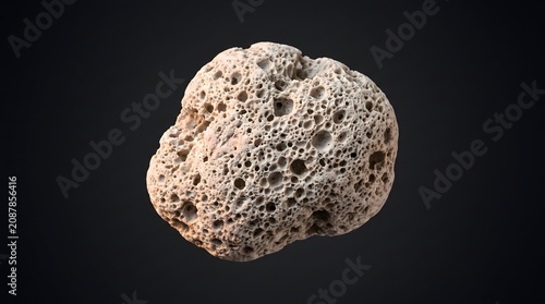A single porous volcanic pumice stone isolated against a dark background