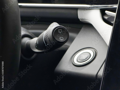 Car interior with start stop button and windshield wiper lever. Modern vehicle dashboard control system for driving. Automotive technology engineering and driver convenience interface.