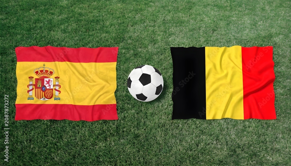Fototapeta premium Spain and belgium national flags waving with a soccer ball on a green grass field