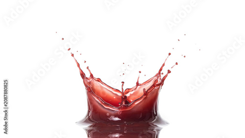 Dynamic crown shaped splash of red liquid or fruit juice rising upwards with small droplets isolated on a solid black background, for advertising