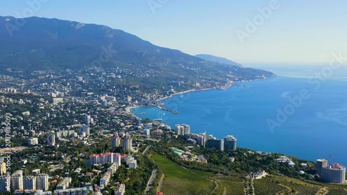 Yalta, Crimea. Panorama of the city in sunny weather. Embankment and port. Drone footage