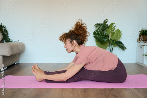Canvastavla Woman doing yoga stretching at home for wellness