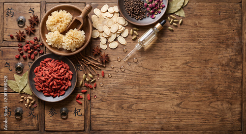 Overhead flat lay of traditional Chinese medicine wellness ingredients on vintage woodac
