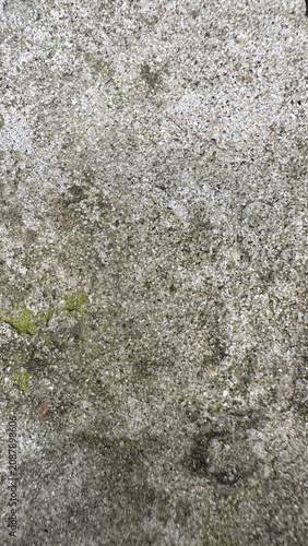 Texture of weathered gray concrete with moss patches