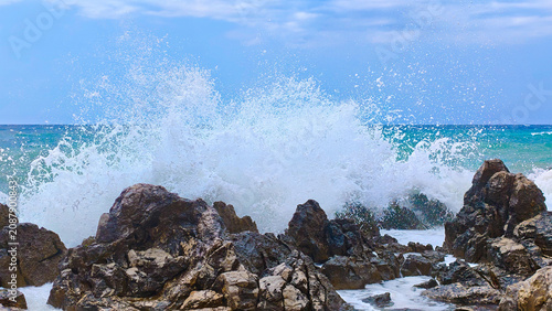 фотографія The sea waves are crashing against the rock