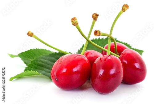 Sweet cherry berries with green leaves on white background