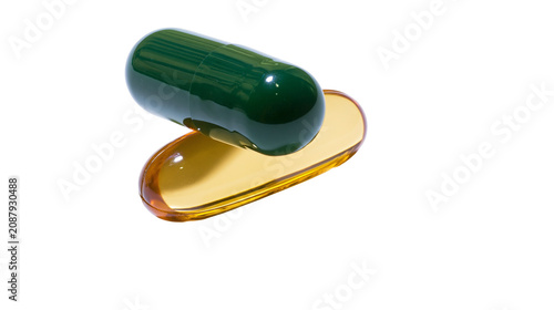 Konstfotografi Green gelatin capsule resting on a translucent amber liquid drop, isolated on tr