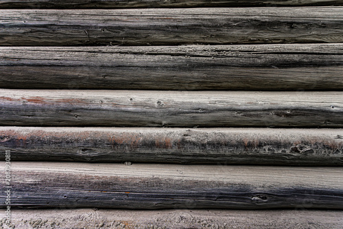 Weathered grey wooden log wall