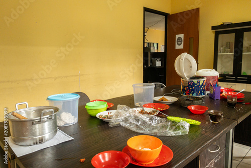 Принти на полотні Messy Kitchen Table With Leftover Food Plates, Rice Cooker and Cups After Casual