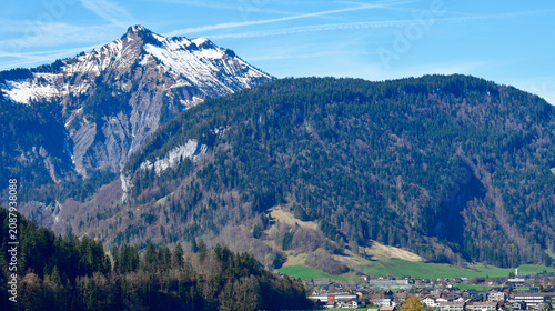 Canvas Print Idyllischer Blick über grüne Frühlingswiesen auf Bezau im Bregenzerwald vor der