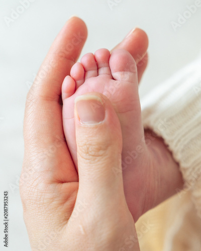 Newborn baby feet in hand close up