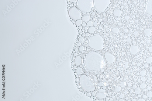 The texture of the foam of shower gel or soap suds or shaving foam. Macrophotography. Copy space