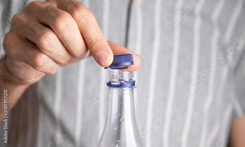 Man opening bottle of water. Close Up view