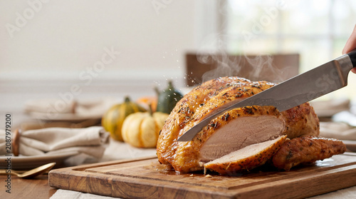 Carving a Steaming Hot Roasted Turkey at a Festive Table Setting
