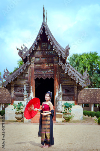 Beautiful Asian Woman in Traditional Lanna Costume at Wat Ton Kwen Ancient Wooden Temple, Chiang Mai, Thailand