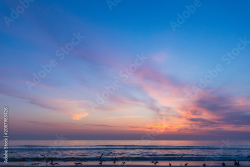 Foto dramatic photograph of an Atlantic coastal sunset, showing a dark, turbulent sea