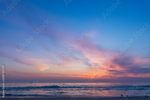 Photos dramatic photograph of an Atlantic coastal sunset, showing a dark, turbulent sea