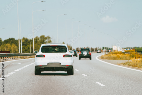 Tableau sur toile Rear view of white car on highway.