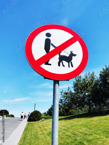 Vertical photo of sign prohibiting dog walking in park. Park area. Prohibition. Dog walking.