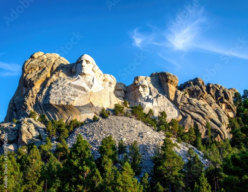 Iconic Mount Rushmore National Memorial under a bright blue sky.