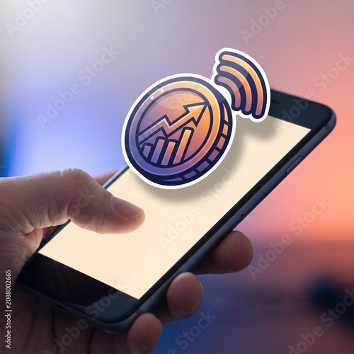 Professional hand holding smartphone with floating finance growth icon in a modern tech environment.