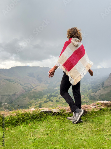 фотографія Woman wearing poncho standing and enjoying views of Andes mountains in Peru