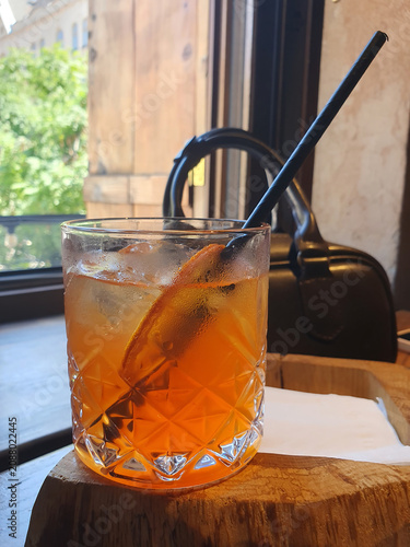 Refreshing Orange Cocktail with Ice in Crystal Glass by a Window