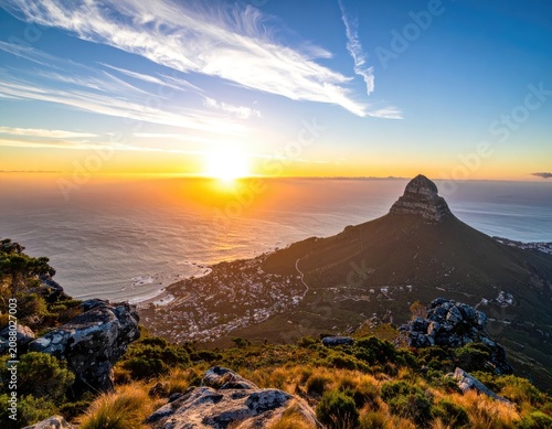 Sunrise over the ocean with Lion's Head mountain and Cape Town coastline.