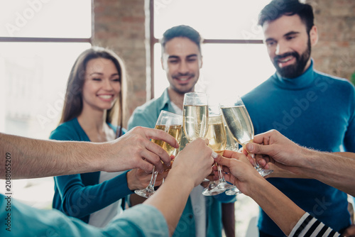 Obraz na plátně Colleagues toasting with champagne in a bright modern office celebrating team su