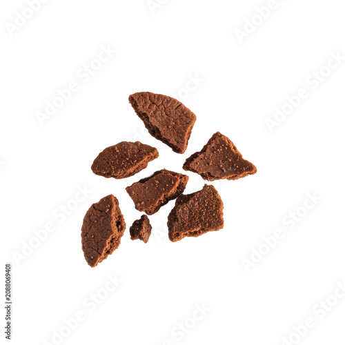 Dynamic scattering of rich dark cocoa brown chocolate cookie crumbs and fine particles, macro high-speed shot against a transparent studio background with copy space. Concept of food texture