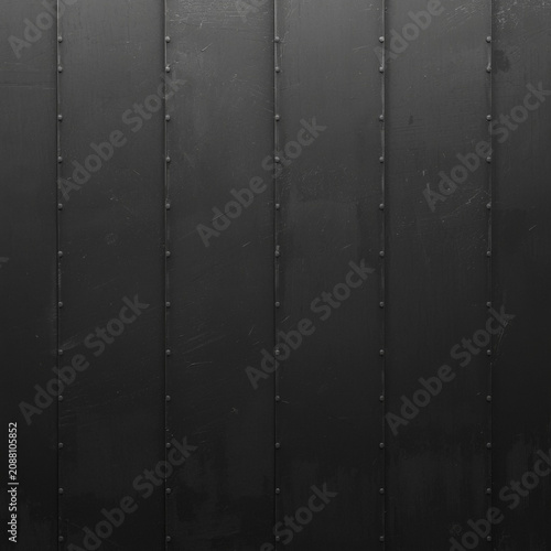 Dark metal surface featuring industrial steel panels joined by visible rivet fasteners showing weathered scratched texture for architectural background.