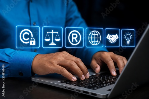 Businessman typing on laptop with intellectual property icons floating above