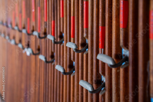 Foto Empty coat hooks in a repeating pattern on a wooden wall, suggesting absence and