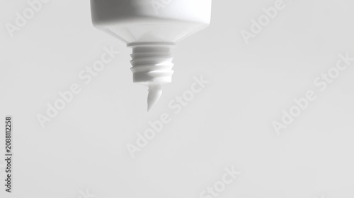 Cosmetic lotion, cream in packaging slowly flows out, front view, neutral light background.