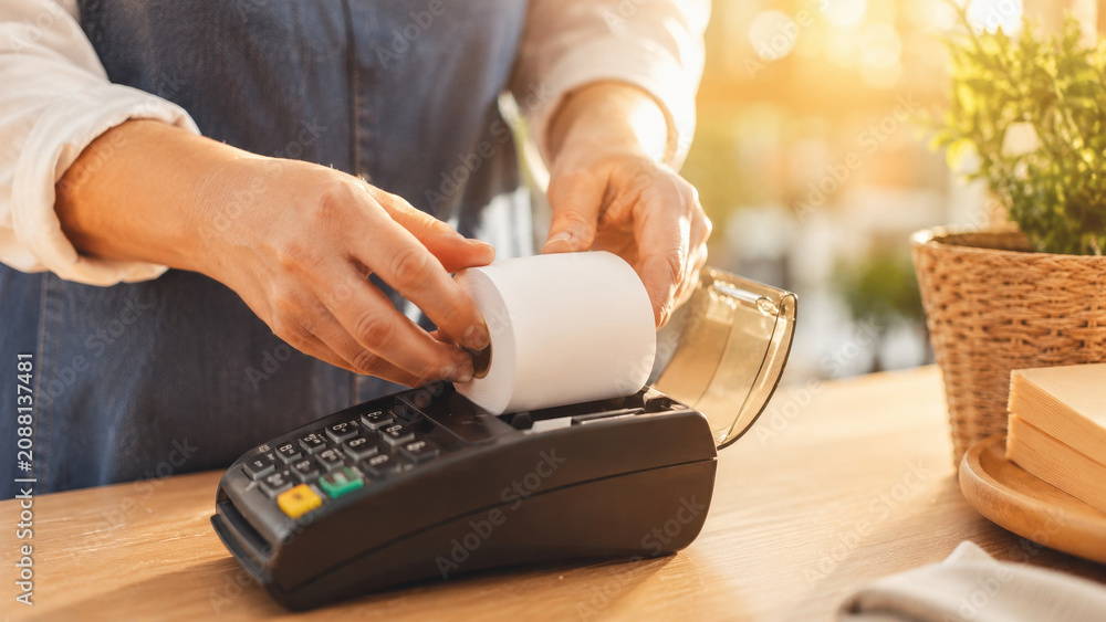 Fototapeta premium Person using card payment terminal with receipt
