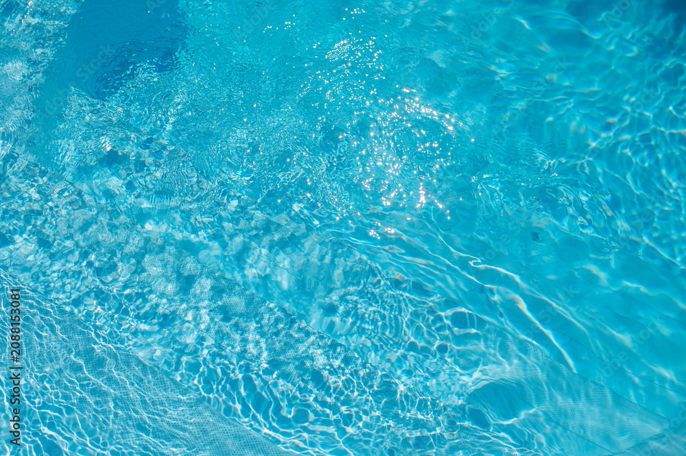 Fototapeta premium Bright blue swimming pool water with sun reflections and gentle ripples