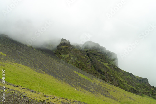 Foto Misty ridge with black scree and green moss on a steep mountainside, Iceland